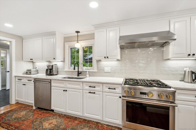 10 Craigmoor Rd, West Hartford, CT 06107 - kitchen featuring appliances with stainless steel finishes, wall chimney exhaust hood, decorative backsplash, white cabinets, and recessed lighting