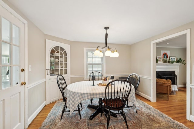 10 Craigmoor Rd, West Hartford, CT 06107 - dining space featuring light wood-type flooring, a chandelier, and a fireplace