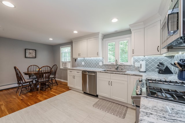 kitchen with stainless steel appliances, healthy amount of natural light, decorative backsplash, white cabinetry, and recessed lighting