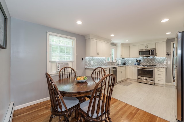 dining space featuring a baseboard radiator, light wood-style flooring, recessed lighting, and cooling unit