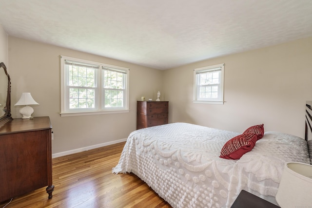 bedroom with wood finished floors and baseboards
