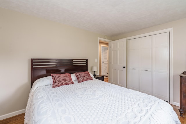 bedroom with wood finished floors and a closet