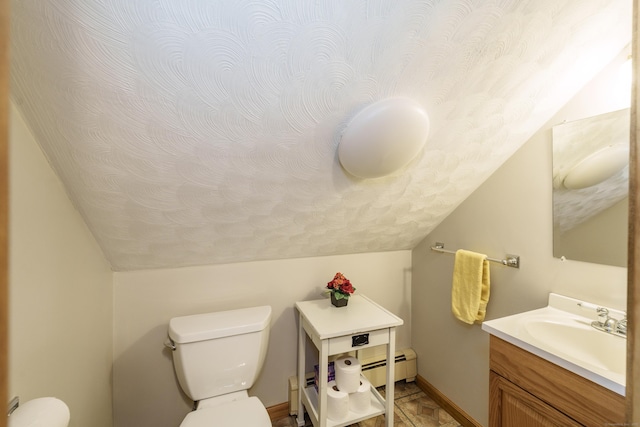 bathroom with vaulted ceiling, vanity, and baseboard heating