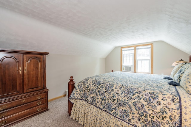 bedroom with light carpet, lofted ceiling, cooling unit, and a textured ceiling
