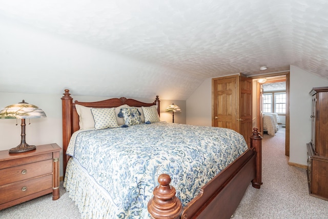 bedroom with light carpet and lofted ceiling
