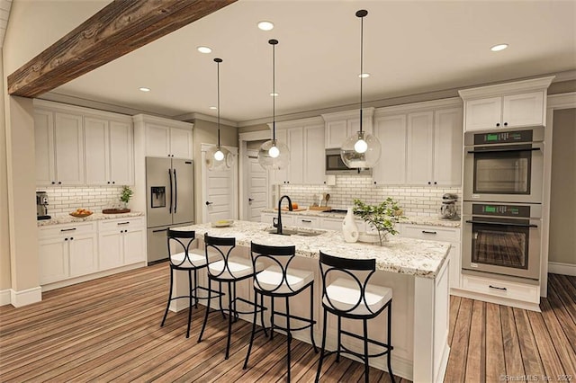 365 Cranberry Bog Rd, Killingly, CT 06239 - kitchen featuring appliances with stainless steel finishes, decorative backsplash, white cabinetry, dark wood-style floors, and hanging light fixtures