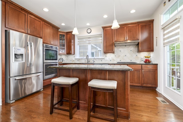 8 Country View Rd Unit 8, Danbury, CT 06810 - kitchen with appliances with stainless steel finishes, under cabinet range hood, dark wood-style flooring, dark stone countertops, and a center island