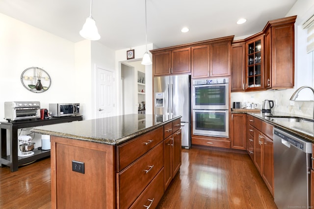 8 Country View Rd Unit 8, Danbury, CT 06810 - kitchen featuring appliances with stainless steel finishes, dark wood finished floors, dark stone countertops, glass insert cabinets, and pendant lighting