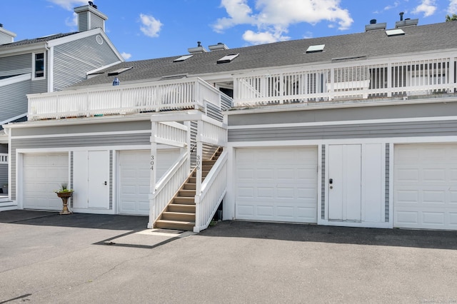 233 Mansfield Grove Rd Unit 306, East Haven, CT 06512 - back of property with a shingled roof, a chimney, a balcony, stairway, and a garage