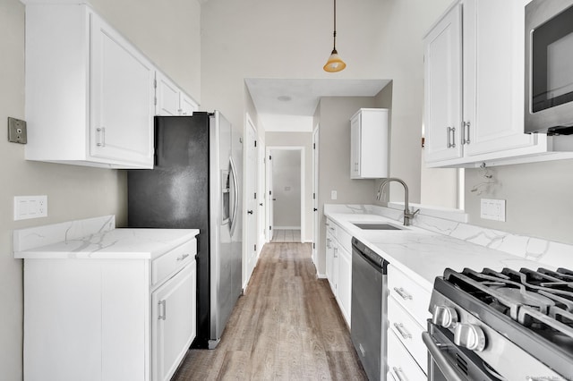 233 Mansfield Grove Rd Unit 306, East Haven, CT 06512 - kitchen with stainless steel appliances, light wood-style flooring, white cabinetry, light stone counters, and decorative light fixtures