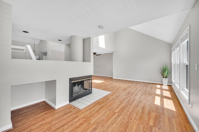 233 Mansfield Grove Rd Unit 306, East Haven, CT 06512 - unfurnished living room featuring light wood finished floors, a ceiling fan, a multi sided fireplace, and vaulted ceiling