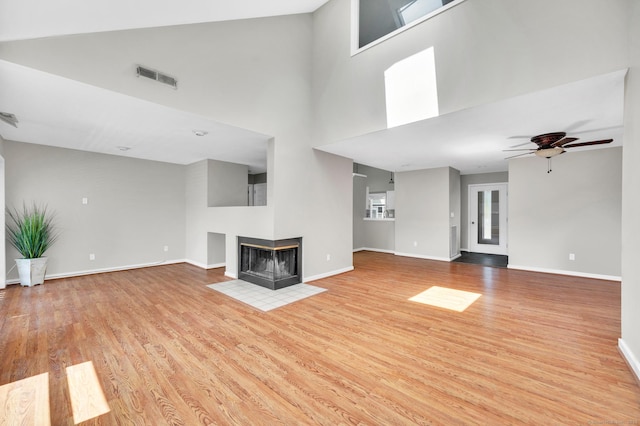 233 Mansfield Grove Rd Unit 306, East Haven, CT 06512 - unfurnished living room with wood finished floors, ceiling fan, a multi sided fireplace, and a high ceiling