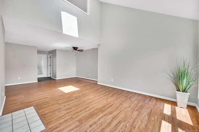 233 Mansfield Grove Rd Unit 306, East Haven, CT 06512 - unfurnished living room featuring wood finished floors, ceiling fan, and a towering ceiling