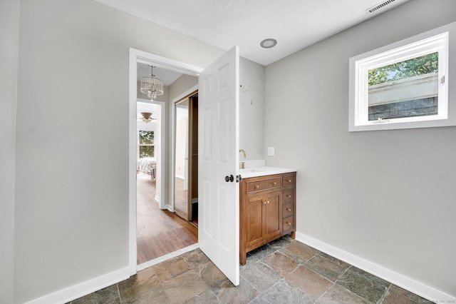 233 Mansfield Grove Rd Unit 306, East Haven, CT 06512 - bathroom with stone finish floors, vanity, and a chandelier