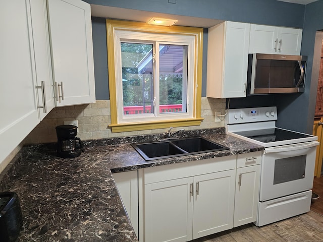 1190 Meriden Rd, Waterbury, CT 06705 - kitchen featuring stainless steel microwave, white electric range, white cabinetry, tasteful backsplash, and light wood-style floors