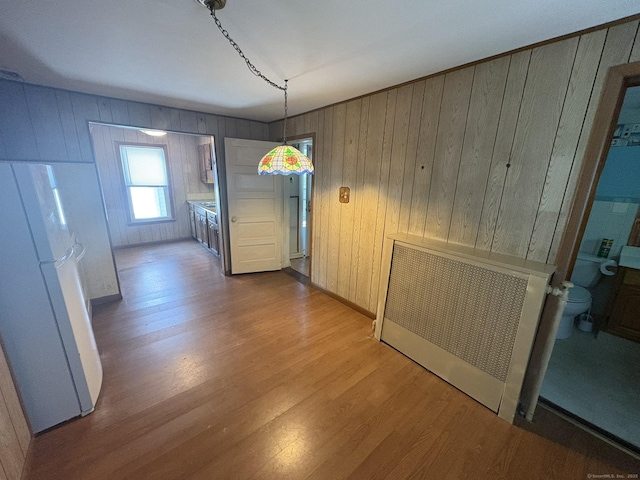 2 Sherwood St, Branford, CT 06405 - unfurnished dining area with wood finished floors, wood walls, and radiator
