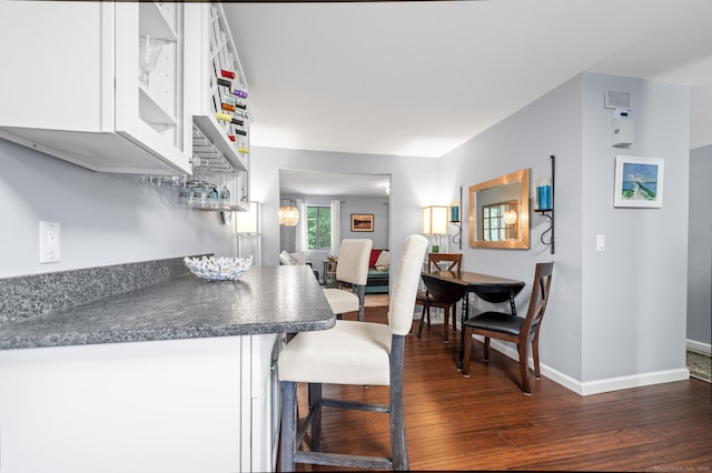 14 Conestoga Way Unit 14, Glastonbury, CT 06033 - kitchen featuring dark wood-style floors, white cabinetry, dark countertops, and a kitchen breakfast bar