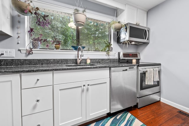 14 Conestoga Way Unit 14, Glastonbury, CT 06033 - kitchen featuring stainless steel appliances, dark wood-style flooring, white cabinetry, and dark stone counters