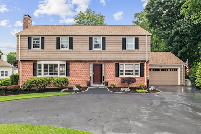 1182 N Main St, West Hartford, CT 06117 - colonial-style house featuring a garage, a chimney, asphalt driveway, and brick siding