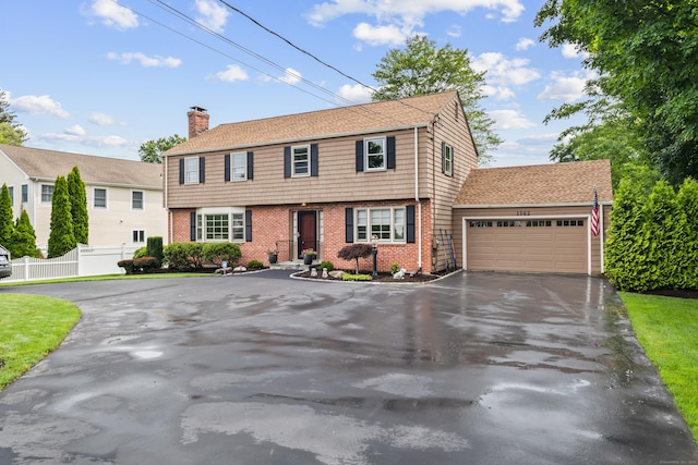 1182 N Main St, West Hartford, CT 06117 - colonial-style house featuring driveway, an attached garage, brick siding, and a chimney
