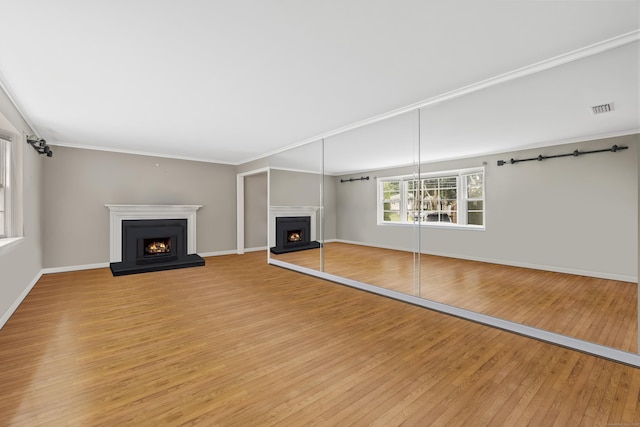 1182 N Main St, West Hartford, CT 06117 - unfurnished living room featuring a lit fireplace, light wood-style floors, and ornamental molding