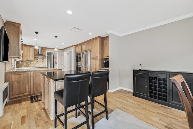 1182 N Main St, West Hartford, CT 06117 - kitchen with a kitchen island, wall chimney range hood, ornamental molding, light wood-type flooring, and tasteful backsplash