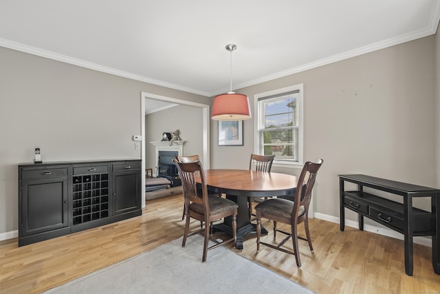 1182 N Main St, West Hartford, CT 06117 - dining space featuring light wood-style flooring, crown molding, and a fireplace