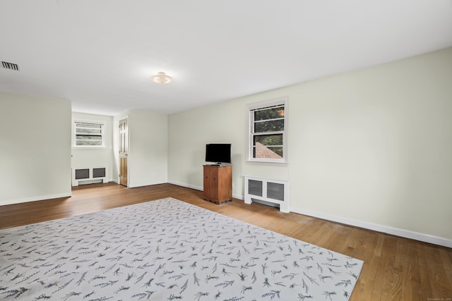 1182 N Main St, West Hartford, CT 06117 - unfurnished living room with wood finished floors, healthy amount of natural light, and radiator