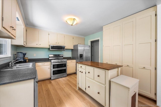 46 Union Dr, Ashford, CT 06278 - kitchen featuring stainless steel appliances, cream cabinets, a center island, and light wood-style floors