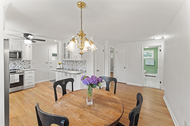 119 Debra Ln, Bristol, CT 06010 - dining area featuring a baseboard radiator, light wood-style flooring, ceiling fan, and a chandelier
