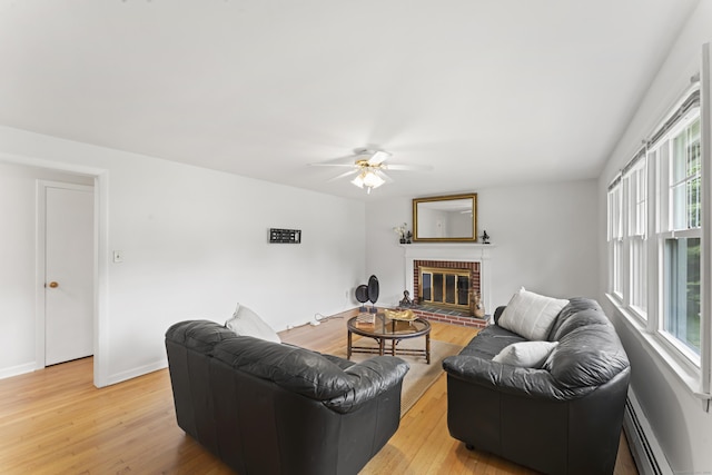 119 Debra Ln, Bristol, CT 06010 - living room with a baseboard heating unit, light wood-style floors, a ceiling fan, and a fireplace