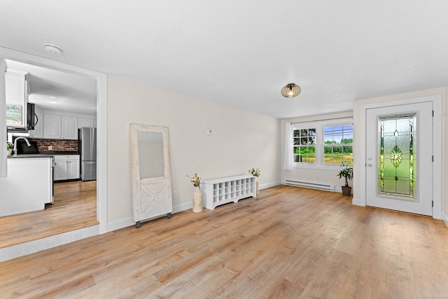 148 Depot St, East Windsor, CT 06016 - unfurnished living room featuring a baseboard heating unit and light wood-style flooring