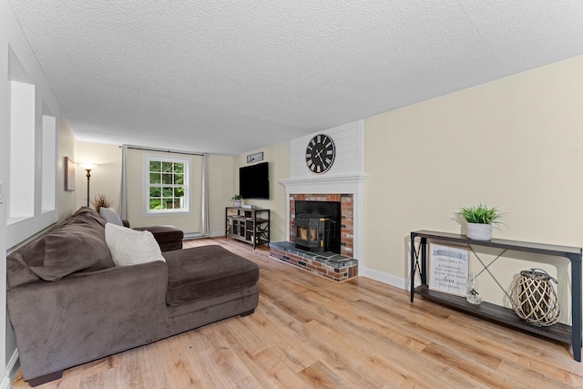 148 Depot St, East Windsor, CT 06016 - living room with a textured ceiling, wood finished floors, and a brick fireplace