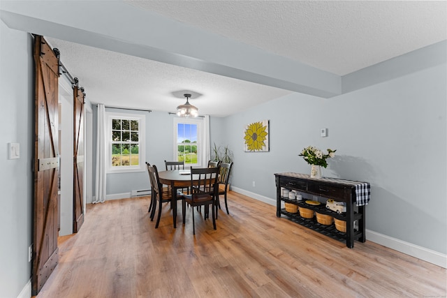 148 Depot St, East Windsor, CT 06016 - dining space with a barn door, a textured ceiling, and light wood finished floors
