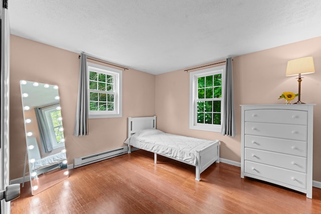 148 Depot St, East Windsor, CT 06016 - bedroom featuring baseboard heating, wood finished floors, multiple windows, and a textured ceiling
