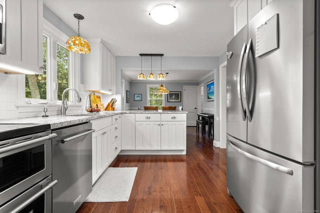 50 Spring Glen Dr, Granby, CT 06035 - kitchen featuring appliances with stainless steel finishes, a peninsula, healthy amount of natural light, and white cabinets