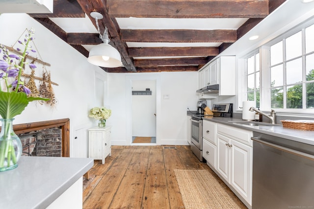 319 Main St, Wethersfield, CT 06109 - kitchen with appliances with stainless steel finishes, beamed ceiling, light wood finished floors, white cabinets, and under cabinet range hood