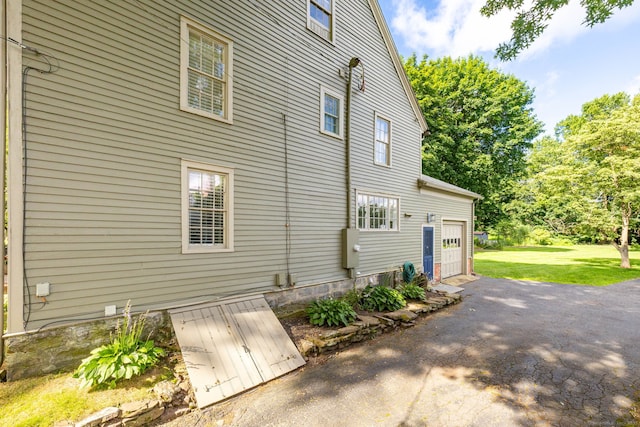 319 Main St, Wethersfield, CT 06109 - view of home's exterior featuring asphalt driveway, a yard, and a garage