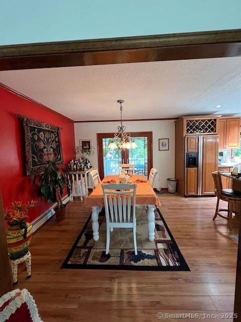 38 Pine St, Trumbull, CT 06611 - dining area with light wood-style floors, a baseboard heating unit, a chandelier, and ornamental molding