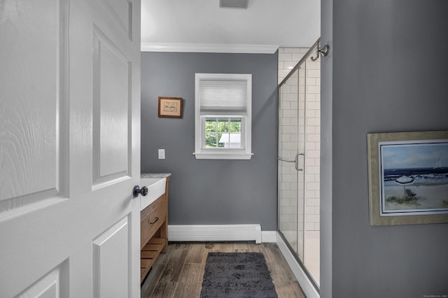 18 Holly Ln, Wallingford, CT 06492 - bathroom featuring baseboard heating, a shower stall, wood finished floors, vanity, and ornamental molding