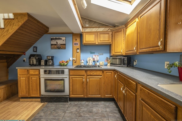 72 S Rd, Portland, CT 06480 - kitchen featuring appliances with stainless steel finishes, vaulted ceiling, a skylight, and brown cabinetry