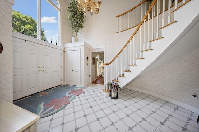 21 Hidden Pond Dr, Watertown, CT 06795 - foyer entrance featuring a chandelier, wallpapered walls, tile patterned floors, stairway, and a towering ceiling
