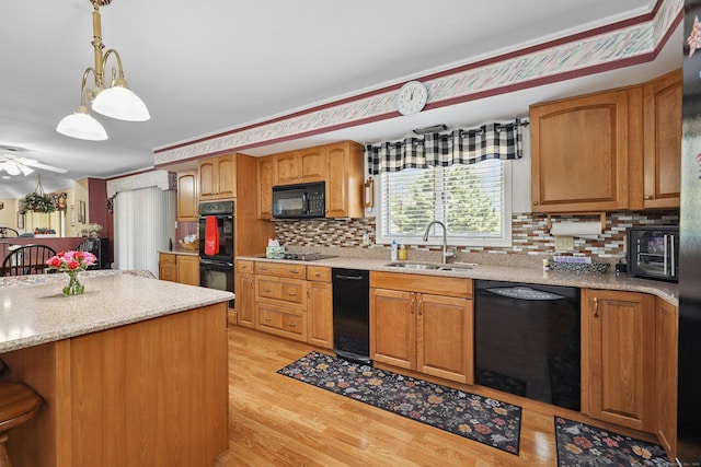 21 Hidden Pond Dr, Watertown, CT 06795 - kitchen with black appliances, tasteful backsplash, light wood finished floors, and pendant lighting