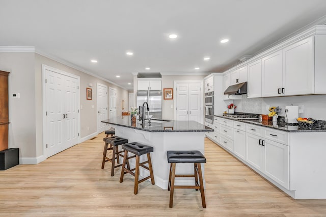 54 Pondview Cir Unit 54, Beacon Falls, CT 06403 - kitchen with under cabinet range hood, crown molding, recessed lighting, a kitchen bar, and stainless steel appliances