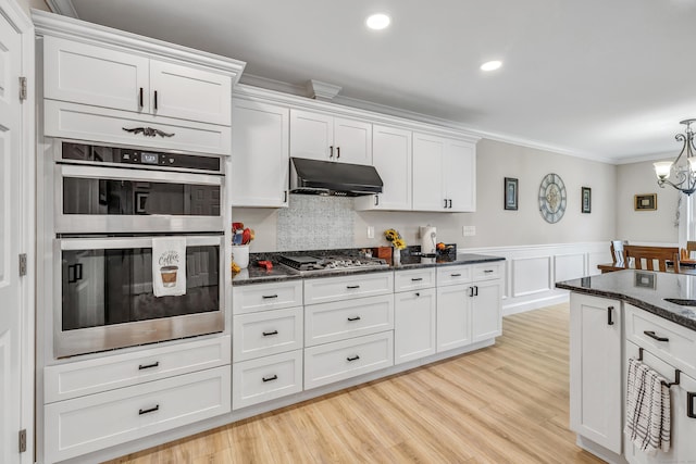 54 Pondview Cir Unit 54, Beacon Falls, CT 06403 - kitchen featuring stainless steel appliances, under cabinet range hood, crown molding, white cabinets, and dark stone counters