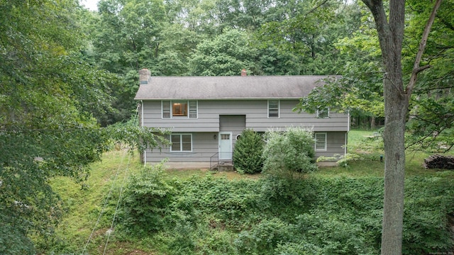16 Skidmore Ln, Newtown, CT 06482 - rear view of property with a chimney and a wooded view