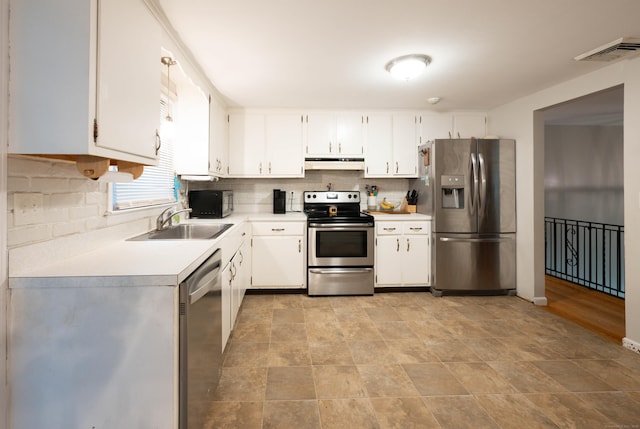 16 Skidmore Ln, Newtown, CT 06482 - kitchen featuring stainless steel appliances, under cabinet range hood, light countertops, and decorative backsplash