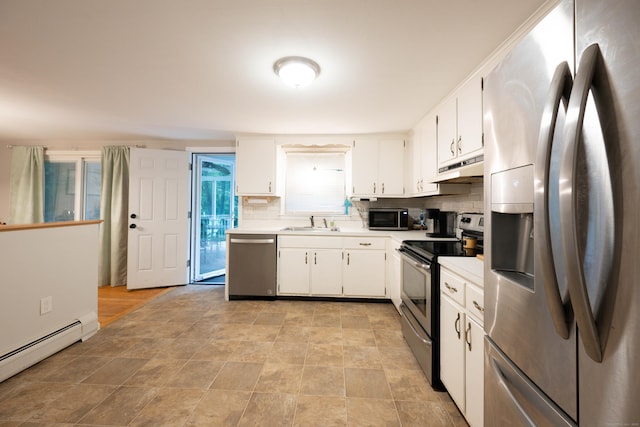 16 Skidmore Ln, Newtown, CT 06482 - kitchen featuring appliances with stainless steel finishes, a baseboard heating unit, tasteful backsplash, and white cabinetry
