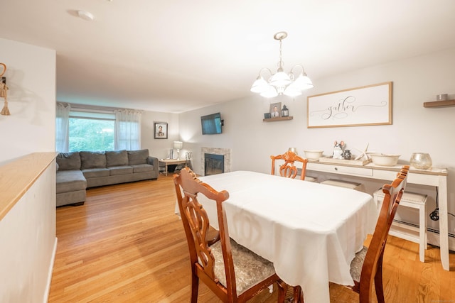 16 Skidmore Ln, Newtown, CT 06482 - dining room with light wood-style floors, a glass covered fireplace, and a chandelier