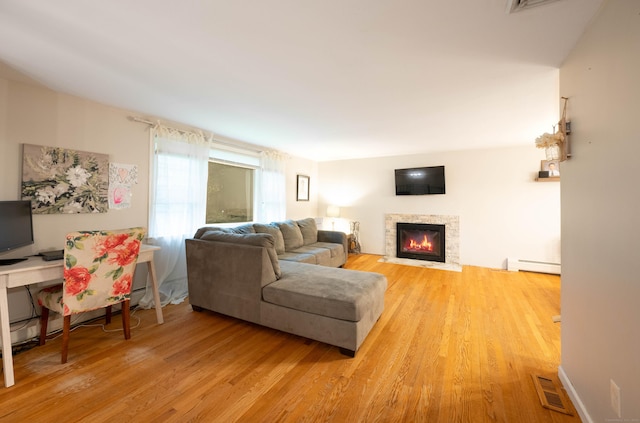16 Skidmore Ln, Newtown, CT 06482 - living room featuring a baseboard heating unit, light wood-style flooring, a fireplace, and an office area